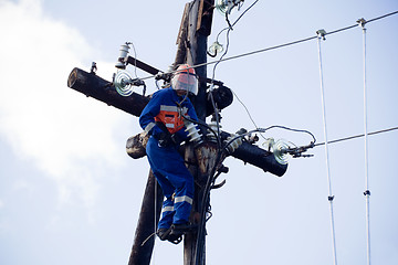 Image showing Electric is working on a pole