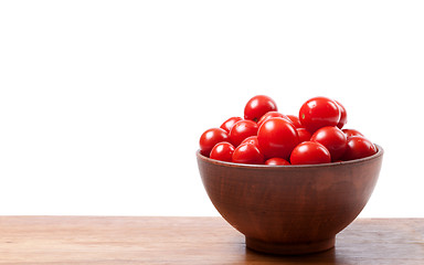 Image showing Cherry tomato in ceramic bowl on wooden kitchen table