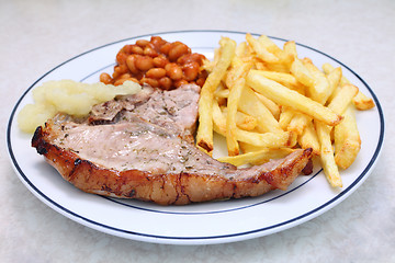 Image showing Grilled pork chop fries beans and sauce