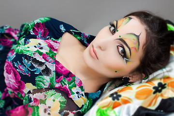 Image showing young happy girl lying with beautiful make up on her face