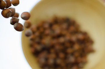 Image showing Hazelnuts in Motion Tumbling into Bamboo Bowl