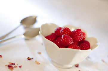 Image showing Cream Pouring From a Jug Over Fresh Raspberries