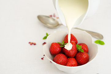 Image showing Cream Pouring From a Jug Over Fresh Strawberries