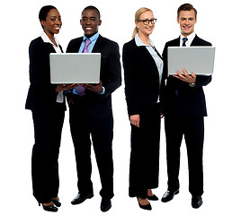 Image showing Two business teams posing with laptop