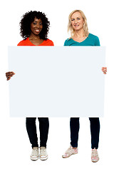 Image showing Two young women holding blank billboard