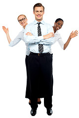 Image showing Female corporate waving hi while man stands tall