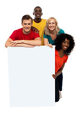 Image showing Group of teenagers displaying white banner