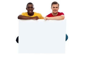 Image showing Casual young guys posing with blank billboard
