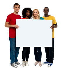 Image showing Team of young people holding whiteboard