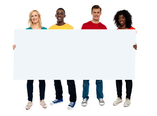 Image showing Confident young group showing blank poster