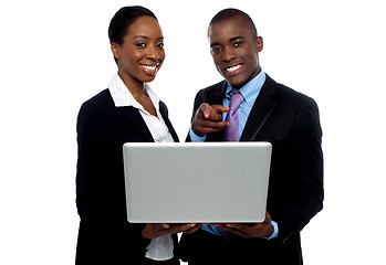 Image showing African coworkers operating laptop and pointing