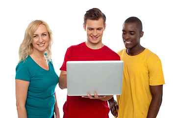 Image showing Cheerful group of friends working on laptop