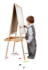 Image showing A child paints on an easel in the studio