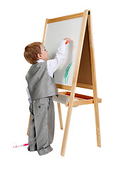 Image showing A child paints on an easel in the studio