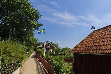 Image showing Narrow street and red cottages in Sweden