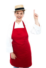 Image showing Joyful middle aged cook pointing upwards