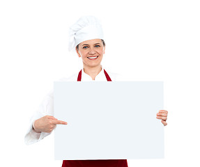 Image showing Female chef pointing towards blank whiteboard