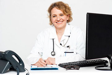 Image showing Smiling middle aged female doctor sitting in clinic