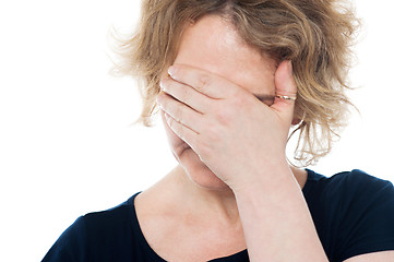 Image showing Unhappy woman hiding her face with hand on it