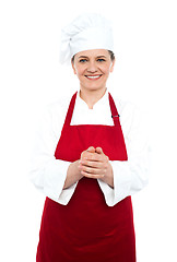 Image showing Smiling aged cook standing in red uniform