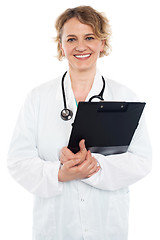 Image showing Smiling senior physician holding clipboard