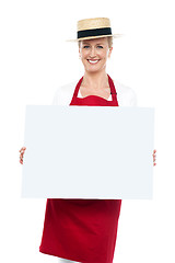 Image showing Portrait of female chef in hat with blank ad board