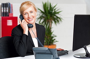 Image showing Secretary talking on phone with client