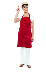 Image showing Female chef wearing hat pointing upwards