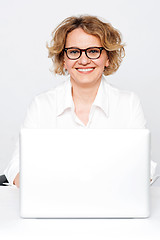 Image showing Smiling businesswoman sitting in front of laptop