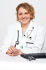 Image showing Confident female surgeon sitting idle, holding pen