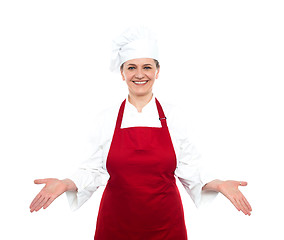 Image showing Senior female chef standing with open palms