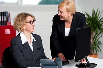 Image showing Joyful businesswomen enjoying at work desk