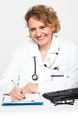 Image showing Happy female physician at work desk