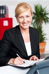 Image showing Female secretary writing on notepad