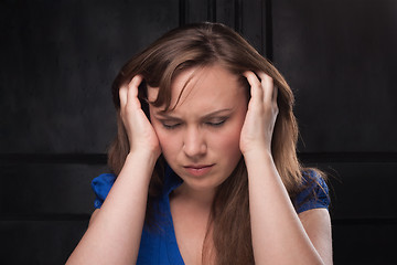 Image showing Girl with headache on dark background