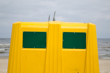 Image showing Closeup of yellow waste bin container on sea beach 