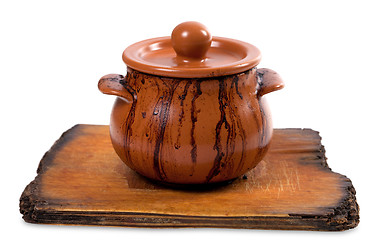 Image showing Dirty ceramic pot on old kitchen board