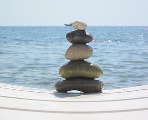 Image showing The stack of pebble stones in zen concept  on chaise longues 