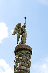 Image showing Angel hold torch on stone platform sky background 