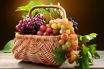 Image showing Basket with pink and black grapes.