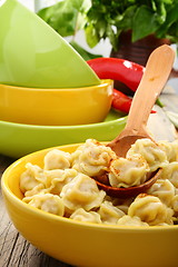 Image showing Dumplings in a bowl and wooden spoon.