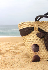 Image showing Seacoast, straw beach bag and sunglasses 	