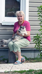 Image showing Woman on a summer residence with a cat on hands