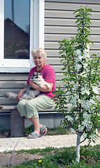 Image showing Woman on a summer residence with a cat on hands