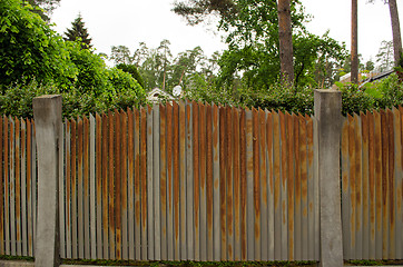 Image showing Old rusty steel metal fence arround house yard 