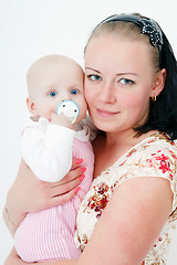 Image showing baby with a pacifier in the arms of mother