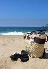 Image showing Seacoast, straw beach bag and flip-flops