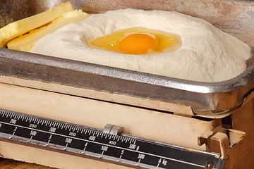 Image showing Kitchen scales with egg butter and flour