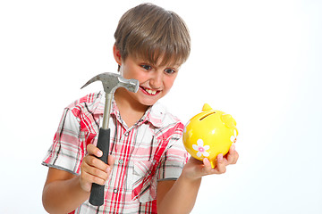 Image showing boy with a hammer breaking a piggybank against white background 