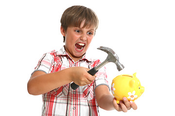 Image showing boy with a hammer breaking a piggybank against white background